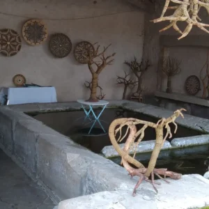 Am Dorfbrunnen weichen Weiden und sind Kunstobjekte ausgestellt