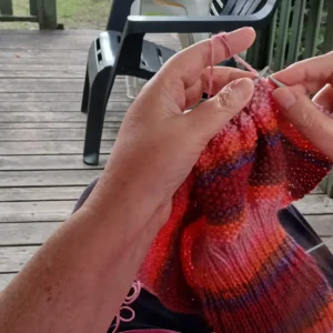 Katja sitzt auf der Terrasse und strickt
