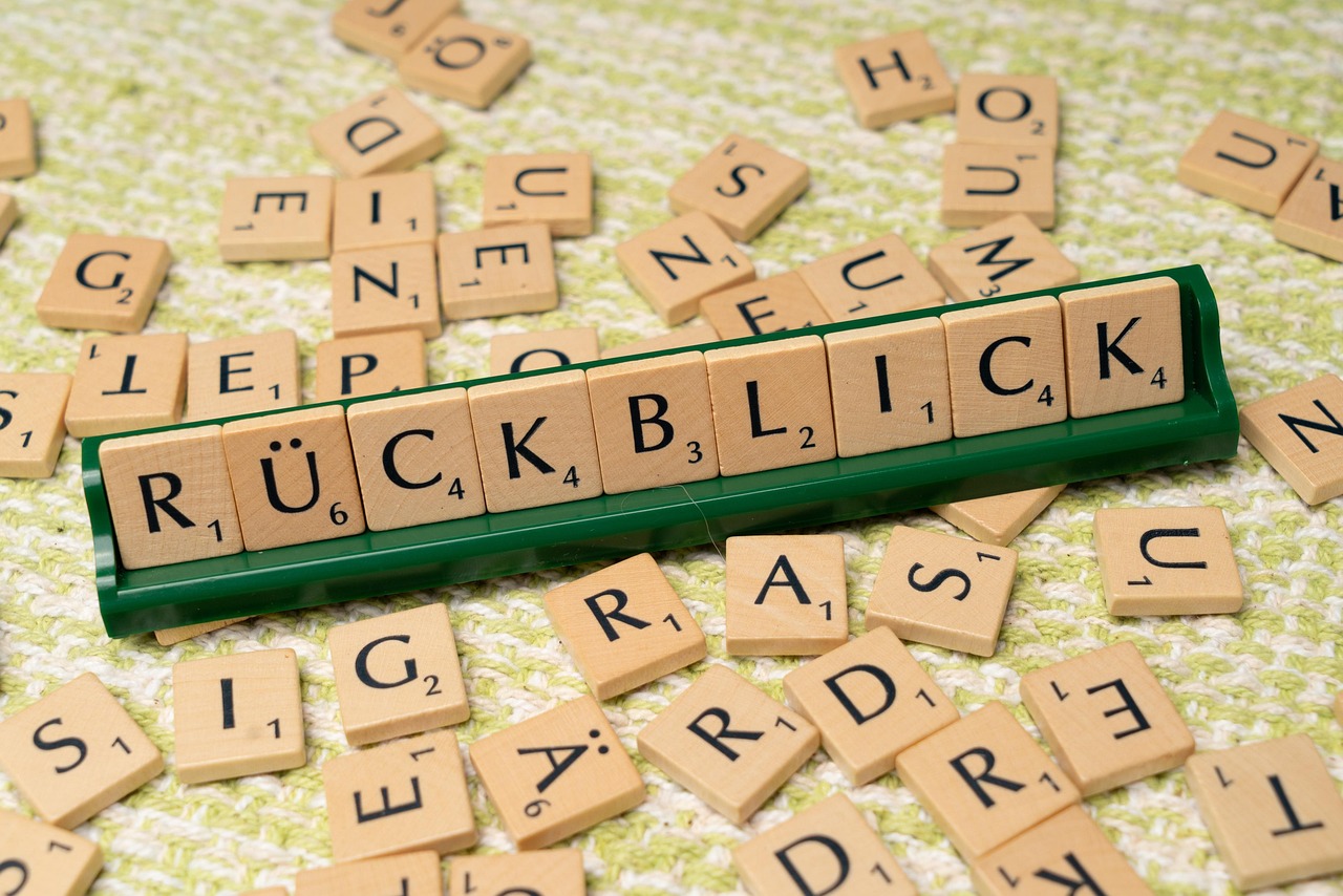 Scrabble Steine aufgereiht als Wort Rückblick mit weiteren liegenden Steinen auf einer Tischplatte