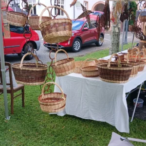 Marktstand zwischen zwei Bäume auf Wiese mit Korbwaren