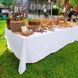 Bauernmarkt Juni 2026 Marktstand zwischen zwei Bäume auf Wiese mit Korbwaren